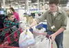 New Three Bears employee Kodi Martin places groceries in the
cart as Rowdy Bailey, 10, watches Saturday morning at the new Three
Bears location at Mile 6 of Knik-Goose Bay Road. (ROBERT
DeBER