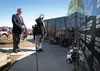 AmVets Post 11 Commander Eugene Zola salutes after placing a wreath at the base of the Veterans Wall of Honor Monday afternoon. Standing to Zola’s right is Robert DeLoach, also with Post 11. 