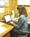 School district public information specialist Kim Floyd works at
her computer in central administration. The district purchased a
used computer server this summer with plans to have a separat
