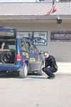 ANDREW WELLNER/Frontiersman An officer with the Wasilla Police
Department examines the scene of a shooting outside Tailgaters Bar
in Wasilla Tuesday morning.