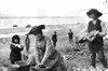 Martha Herning, the wife of O.G., washes clothes in the old
style on the shores of Cook Inlet. Without the benefit of
modern-day insect repellents, the workers were forced to wear
mosquito ne