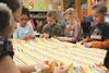 First-grade students in Cathy Ledbetter’s class at Machetanz Elementary School tie blankets Tuesday as part of a project to share Christmas cards, gifts and songs with residents at the Alaska
