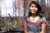 Krystiana Mark, a college-bound graduate of Su Valley High School, sits on a tree recently felled on her parents’ Willow property to make room for a new home after the Sockeye fire. Krystiana