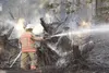 ROBERT DeBERRY/Frontiersman A member of the Mat-Su Central Fire
Department sprays down an area of downed trees and grass off
Foothill Boulevard Friday afternoon.
