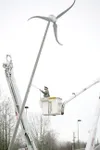 ROBERT DeBERRY/Frontiersman MEA employee Wyatt Schmiege helps to
stabalize the wind turbine as it is raised at Sherrod Elementary
School Friday afternoon.