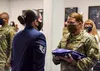 U.S. Air Force Staff Sgt. Kara Tierney, ceremonial guardsman with the Joint Base Elmendorf-Richardson Honor Guard, presents a U.S. flag to U.S. Air Force Technical Sgt. Danielle Shively, with