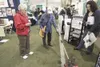 Betty Ann Scheeler, center, test drives an Oreck cordless
sweeper as Lucie Manka, left, and Anchorage Oreck store manager Tia
Leon watch at the Oreck of Wasilla booth at the Fall Home and
Gar