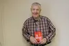 Dr. Lynn Mickleson poses for a photo with his new book, “The Good News File: Hope for a Modern World.” Jacob Mann/Frontiersman