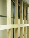 A row of four-inch by six-inch beams now supports the long wall
of the Mat-Su Borough Assembly chambers. In the photo above, the
bowing of the existing wall can be seen by the angled trim pie