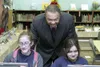Mat-Su Borough School District Superintendent Ken Burnley looks
over the shoulders of two Butte Elementary School students Friday
during a ceremony in the library marking a $10,000 donation f