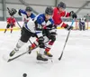 Tyler Virgin and Ryan Dahle of the police team battle Nathan Durbin of the fire team during the Guns N Hoses charity hockey game Saturday, Nov. 23, 2024, at the Menard Arena in Wasilla. J. Da