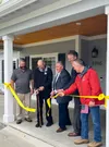 Army Veteran SSG Randall Young, center, cuts the yellow ribbon to his custom built home specially adapted to suit his needs from injuries sustained in Iraq. The home is donated by Homes For O