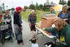 Qahhara Griffin and her daughter Shahzaddie Griffin, 3, and son Firdouse Griffin, 1, go through the Food 4 Kids lunch line at Newcomb Park in Wasilla July 15. HEATHER A. RESZ/Frontiersman.com