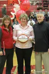 Wasilla High School principal Amy Spargo, left, and activities director Chuck Martin stand with longtime Wasilla High School girls basketball head coacch Jeannie Hebert-Truax during a ceremon