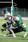 Colony’s Myles Cullenburg and Ryan Ertz take down North Pole’s Garrett Sommer during Friday’s ‘Battle for the Boots’ at Colony High School. North Pole scored a 44-27 win over the Knights. ROB