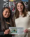Jennifer Cicali, right, receives her grand prize from pilot Christie Pham of Outbound Heli during the Frontiersman's Best of the Valley event Sunday, Oct. 26, at Evangelo's in Wasilla. Outbou