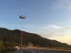 A Chinook helicopter operated by Northern Powerline moves a 140-foot tall light tower into place alongside the Glenn Highway on July 21, 2015. Crews are in the finishing stages of a project t