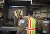 Soldiers and Airmen from the Connecticut National Guard load boxes of face masks into a vehicle at West Hartford Public Works, West Hartford, Conn., Sept. 30, 2020. The Connecticut National G