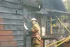 ROBERT DeBERRY/Frontiersman A Mat-Su Central firefighter sprays
down a structure on Esther Drive that caught fire Monday
evening.
