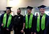 Wyatt Milnes, Zack Bell and Ayden Draper get a quick photo with Redington schools resource officer Joe Opala during Redington's graduation ceremony Wednesday, May 14, 2024, at the Menard Spor