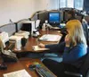 Jacqueline Harding (foreground) and Jody Towsley (background),
dispatchers at the Wasilla Police Department, handle incoming calls
with pen and paper. Once the city of Wasilla puts its nearly