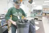 ROBERT DeBERRY/Frontiersman NANA Management custodian Mark
Nelson changes trash can liners at Palmer High School on the last
day of school. The Mat-Su Borough School District board voted to
e