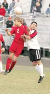 ROBERT DeBERRY/Frontiersman Warrior Aaron Sharrow heads the ball
during the first half of Wasilla’s game against the Kenai Kardinals
Thursday at Wasilla High School.