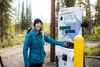 Sara Hall, of ReCharge Alaska, pushes the "start" button at the new fast-charge site in Cantwell. Photo courtesy Golden Valley Electric Association