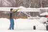 Wasilla resident Darren Rudolph uses a broom to brush snow off his plane at the Palmer Airport in this 2011 file photo. The Mat-Su Borough Assembly has voted to repeal the $75 tax for single-