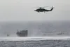 220516-N-TT059-1005 GULF OF OMAN (May 16, 2022) An MH-60R Seahawk from Helicopter Maritime Strike Squadron (HSM) 35, Detachment 1, provides aerial support to an interdiction team from guided-