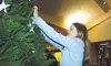 Eleven-year-old Michelle Hauff hangs a teddy bear on the Hospice
of Mat-Su Christmas tree in the Cottonwood Creek Mall Friday. She
wrote the names of her grandmas on two teddy bears and hung 