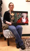 Wasilla artist Lori Teich shows off one of her favorite paintings, an acrylic rendering of albino hip-hop artist and social activist Brother Ali, who reposted a photo of the painting on his I