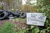 A ‘keep out’ sign sits on the property of John Fraley, where piles of tires have been dumped. ROBERT DeBERRY/Frontiersman.com