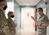 U.S. Air Force Staff Sgt. Jason Henderson, 673d Medical Operations Squadron noncommissioned officer in charge of developmental pediatrics, briefs U.S. Air Force Col. Kirsten Aguilar, Joint Ba