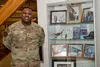 U.S. Air Force Maj. Gabriel Byrd, 525 Fighter Generation Squadron commander at Joint Base Elmendorf-Richardson poses with memorabilia of the Tuskegee Airmen showcased at the 477 Fighter Group