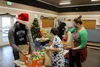 Santa hat-wearing volunteers packed toys, hot cocoa packets, candy canes and other treats into each bag with holiday music playing in the background after receiving their shipment of food fro