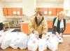ROBERT DeBERRY/Frontiersman Ben Hammond, left, and Georgie
Hollander begin to sort through cans of food donated for the annual
Christmas Day Dinner at Wasilla High School. This is the 17th ye