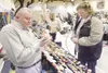 ROBERT DeBERRY/Frontiersman Jim Scarrow, left, writes a name on
a Christmas ornament for customer Pam Osburn-Thomas at the
Matanuska-Susitna Borough building gym during the Colony Chrismas
ce