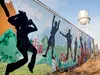 The iconic Palmer water tower stands above a weathered mural painted on a conex container on the old Matanuska Maid property in downtown Palmer Monday afternoon. Palmer City Council members w