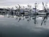 Fishing boats, seen here on Feb. 23, 2018, are reflected in the water at Kodiak's St. Paul Harbor. There are too few resources to help younger Alaskans enter and thrive in the commercial fish