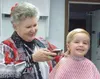 Three-year-old Richard Kinney-Harris sits still for a haircut
from Irene Anderson-Hixson at Wasilla Barber Shop on Railroad Ave.
The shop will mark its 25th anniversary this month. Anderson h