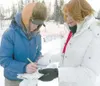 ROBERT DeBERRY/Frontiersman Ryan Redington signs an autograph
Sunday for his Iditarider, Sharron Williamson, before the restart
of 2009 Iditarod Trail Sled Dog Race in Willow. Williamson paid