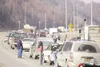 (ROBERT DeBERRY/Frontiersman) Morning commuters stand outside
their vehicles along the Glenn Highway this morning as they wait
for the road to re-open after a standoff between Anchorage polic