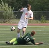 Wasilla's Kyle Broach tries to move past a diving Chris Olsen during Wasilla's 2-1 win over Colony May 24 in the Northern Lights Conference boys' title game at Wasilla High. The teams will me