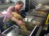 Loose Moose Cafe manager Gwen Harbuck dumps French fries into a fry basket at the restaurant along the Parks Highway in Wasilla. Harbuck's mother, Kathryn Wuitschick, owns the restaurant, whi