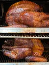 All-natural, house-brined turkeys sit in the smoker at Bear Mountain Meats, which has a variety of holiday dinner table offerings, including Alaska-raised hams and beef rib roasts available a