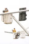 (ROBERT DeBERRY/Froniersman) City Electric employees work on
hanging preemptive emergency signal device on new traffic light
signals above the Parks Highway Thursday afternnoon.