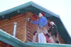 Gage Tree Service employees Darrell Pine, left, and Scott Dennison install holiday lights on a home in Palmer pon Friday, Dec. 4. STEVEN MERRITT/Frontiersman