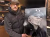 Valley air brush artist Ken Ottinger holds a portrait he painted
of Phil Knight, co-founder and chairman of Nike Inc. Ottinger owns
and operates Ottworks Custom Paint Studio in Wasilla. Recen