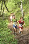 Eight-year-old Shine Carey and her mother, Marika, of Willow, churn up one of the final hills in the fifth annual Red Shirt Lake Trail Run in Willow on Saturday. Emily Ripley, of Wasilla, fol